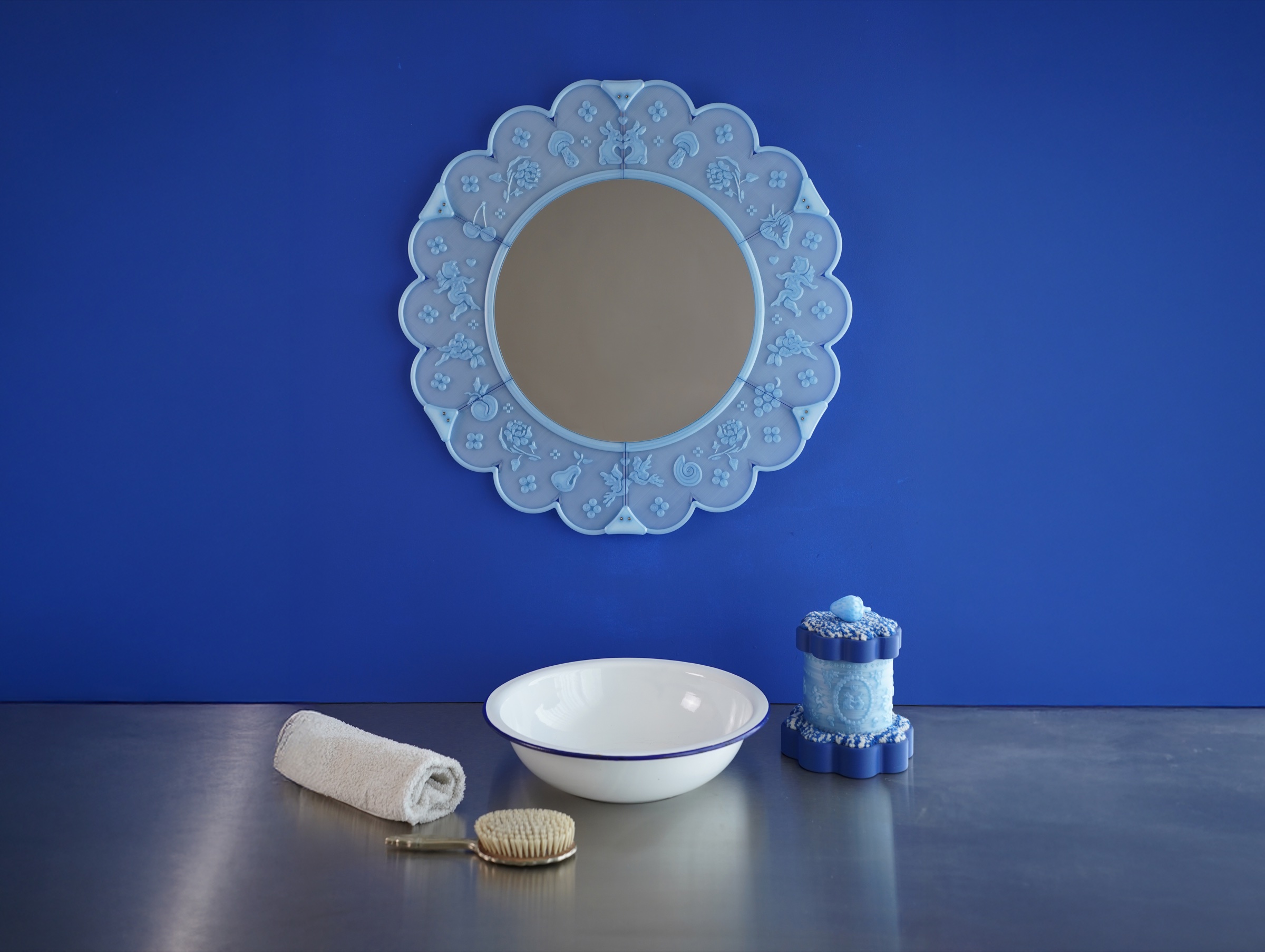 A pale blue lace mirror above a vanity basin against a cobalt blue wall.